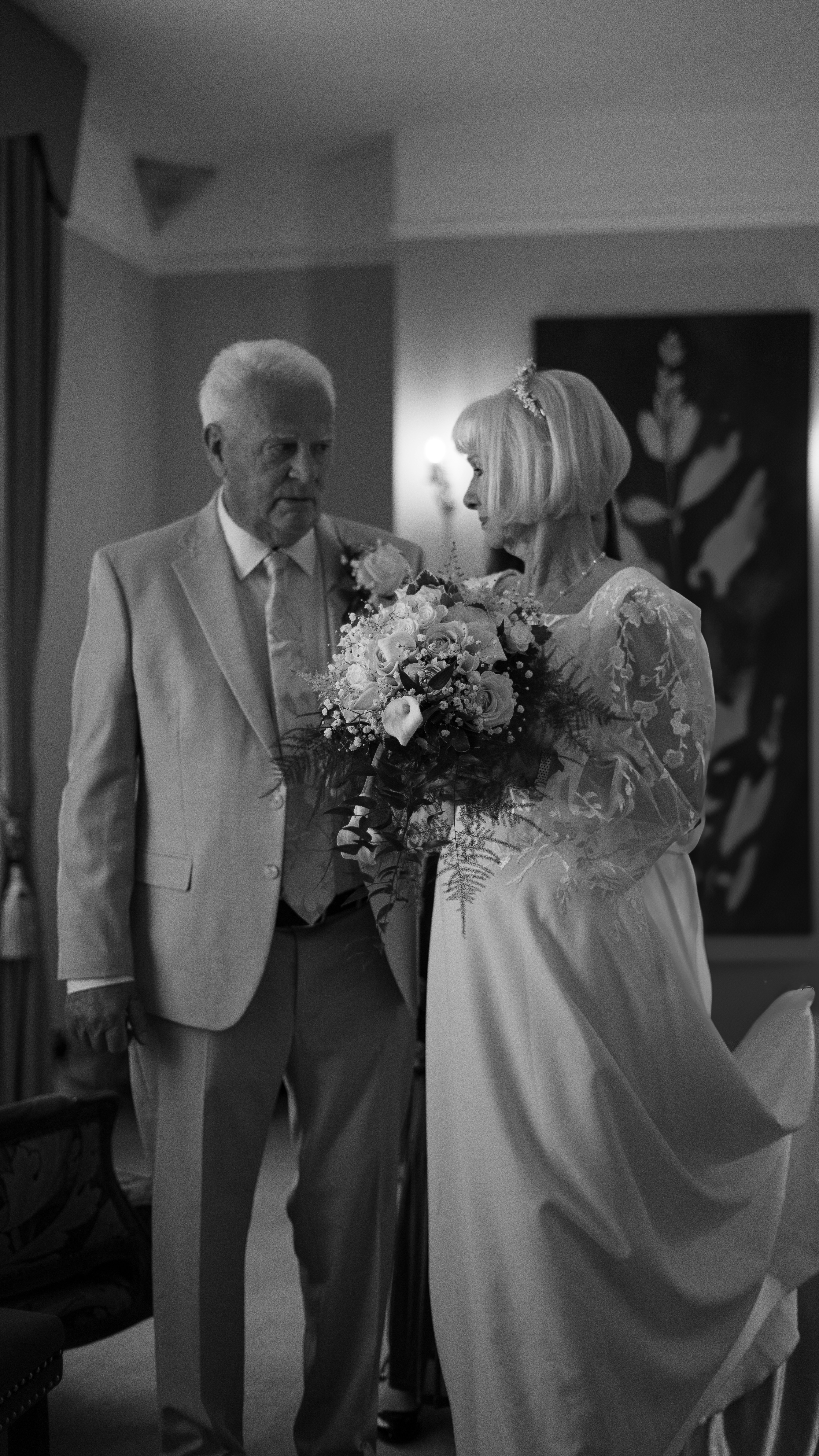Bride and father looking at each other with bouquet.