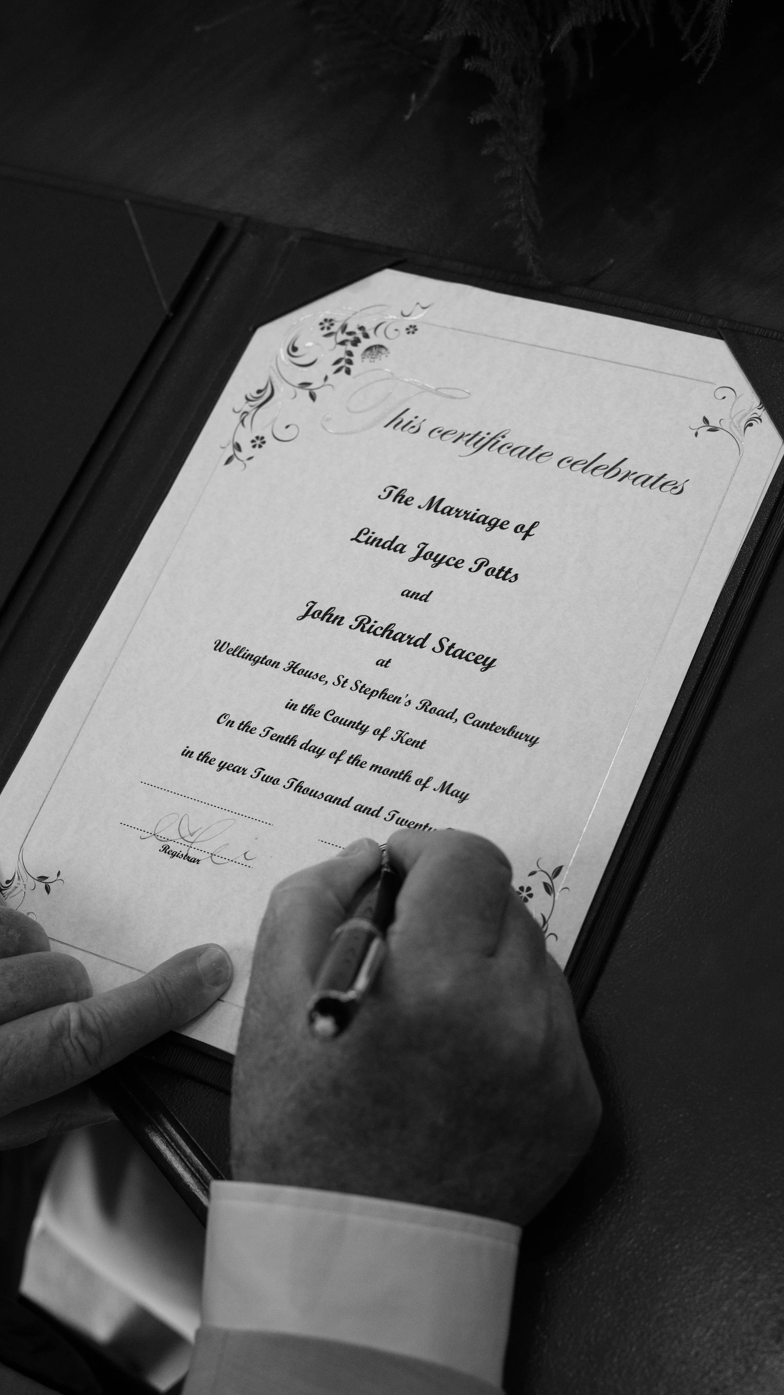 Signature du registre de mariage civil à la commune, un témoin appose son paraphe au stylo