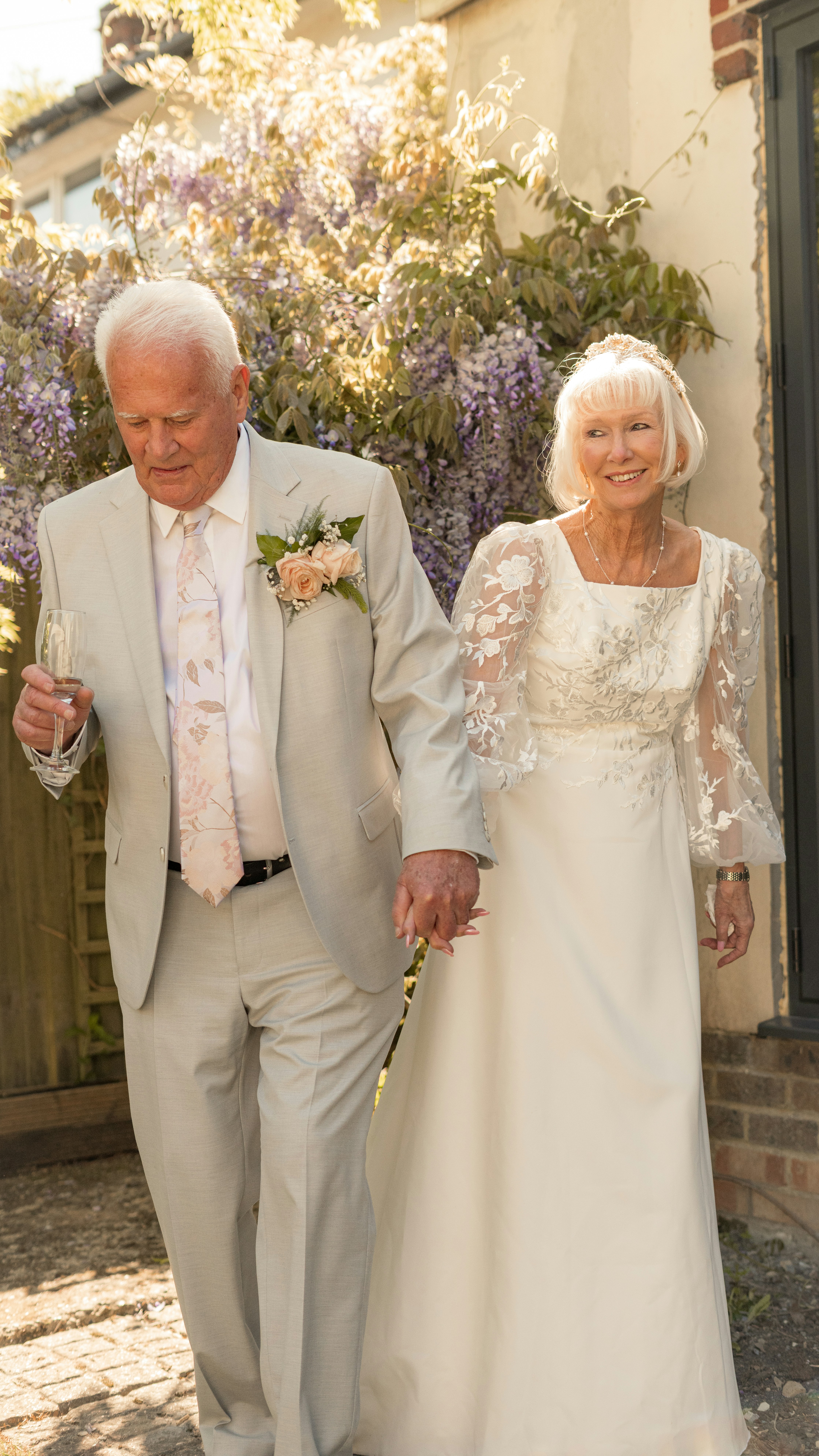 Elderly couple holding hands, celebrating their wedding day