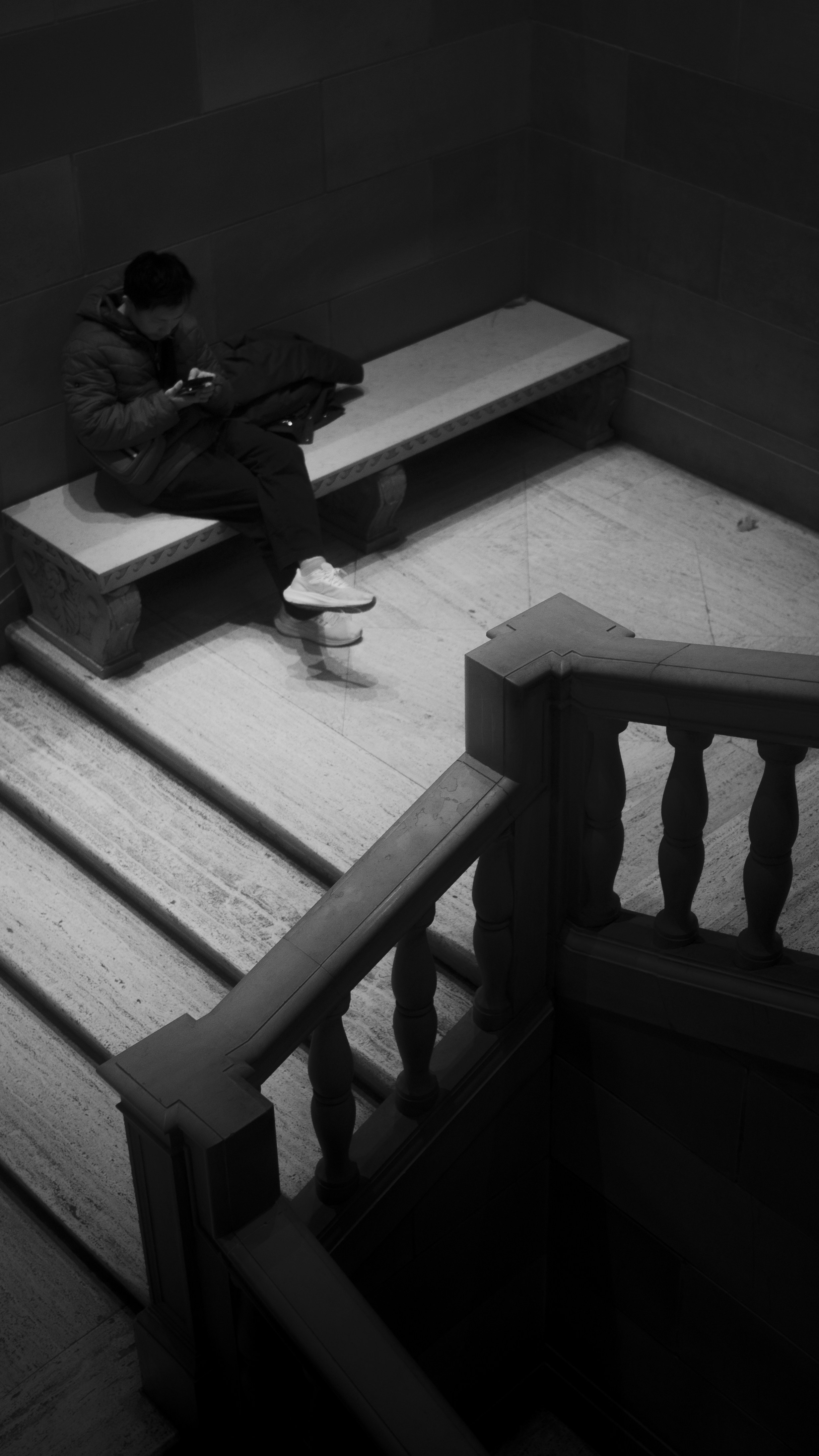 Man sitting on bench using smartphone indoors mobile phone.