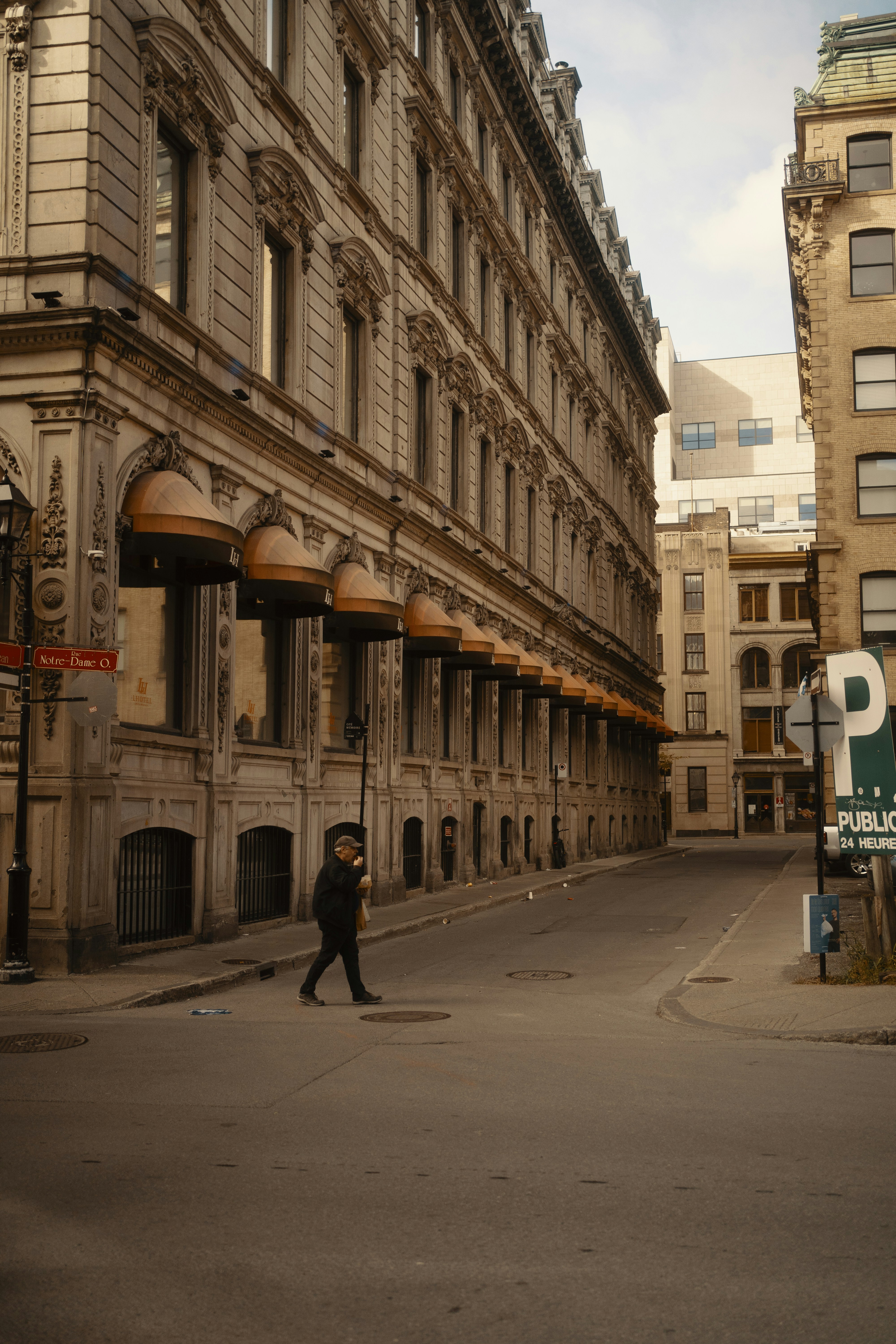 A person walks down a narrow city street.