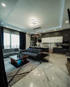 Modern living room and kitchen with dark furniture.