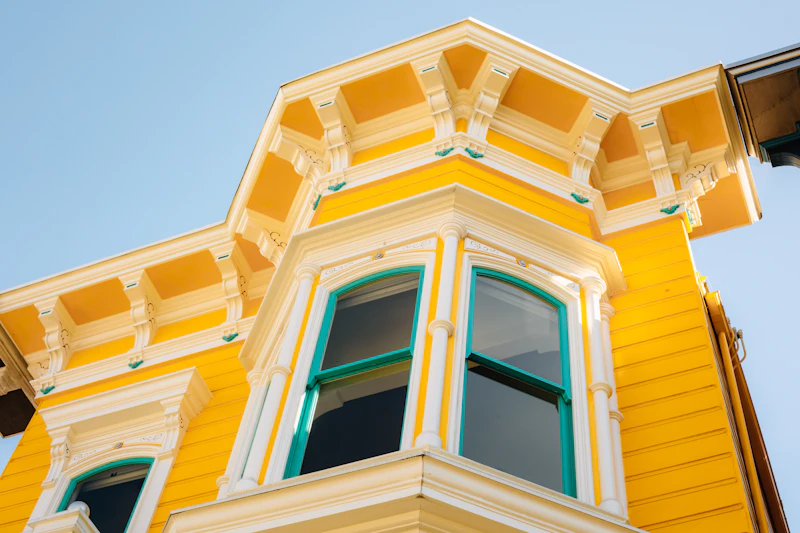 Bright yellow Victorian house with ornate trim