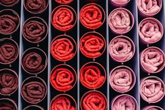 Rolled fabric swatches in shades of red and pink.