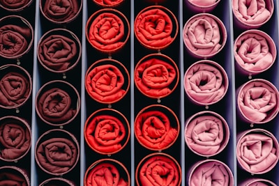 Rolled fabric swatches in shades of red and pink.