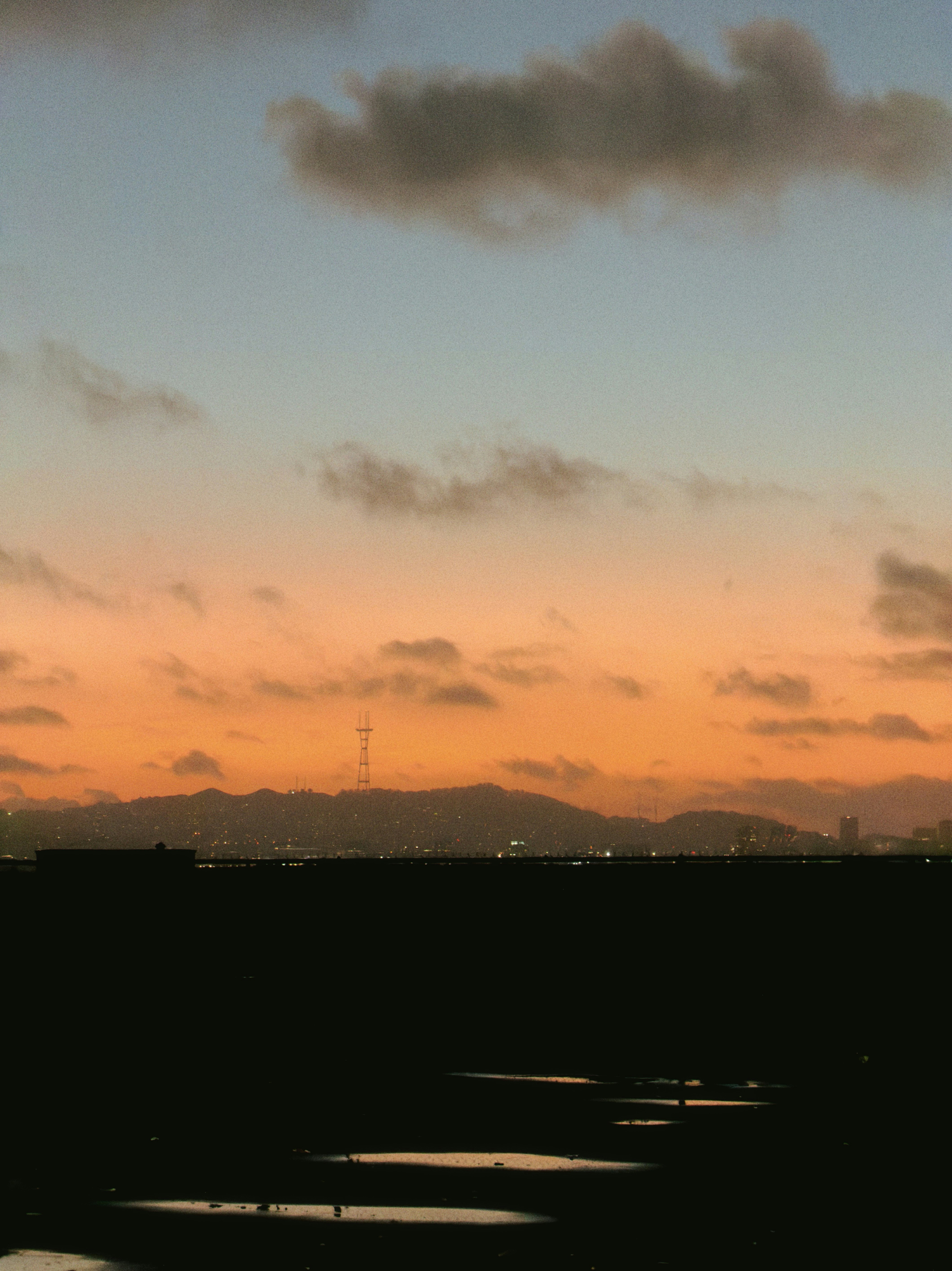 Sunset over a city skyline with mountains