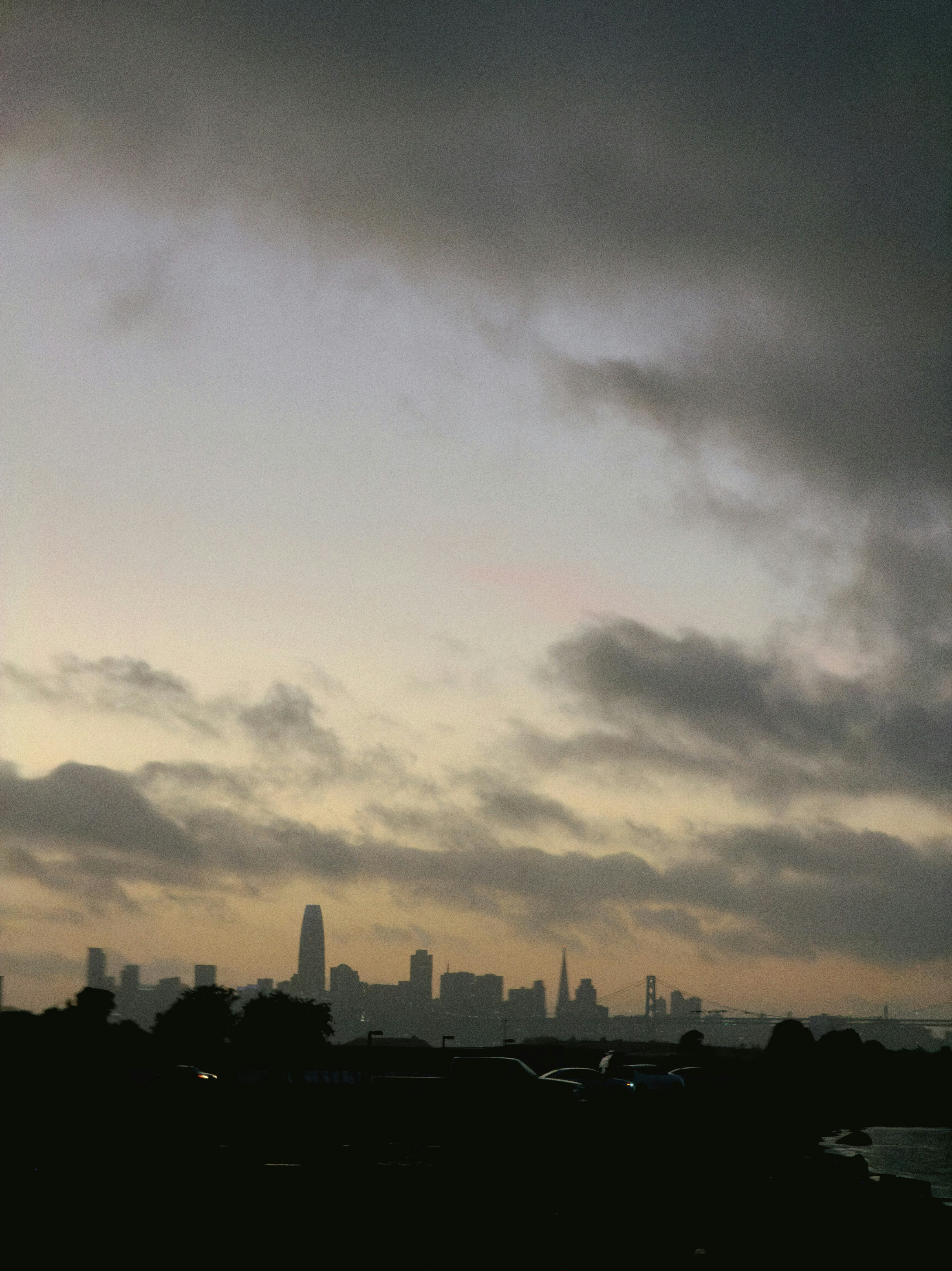 City skyline at dusk with dramatic clouds