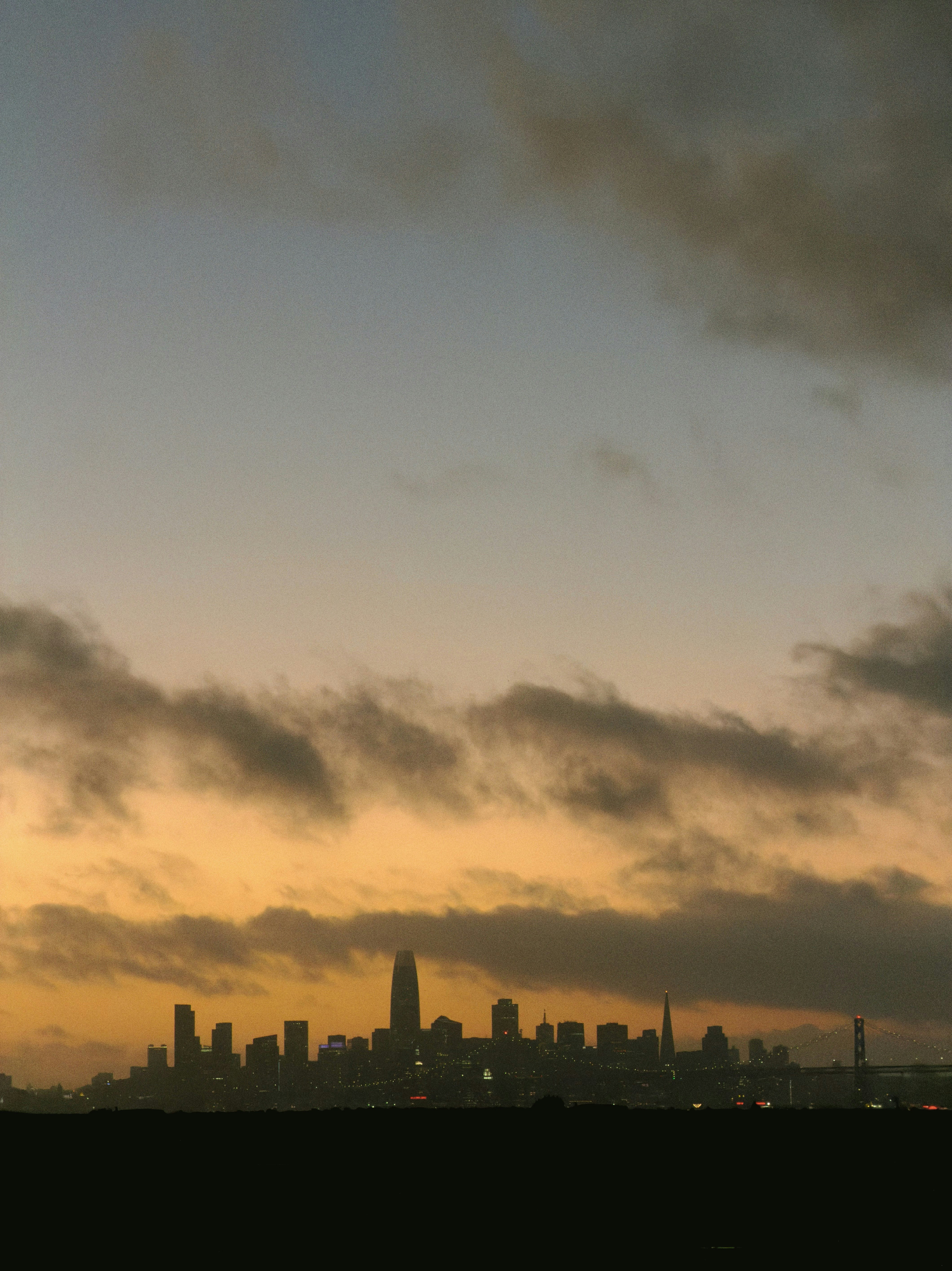 City skyline at dusk with dramatic clouds