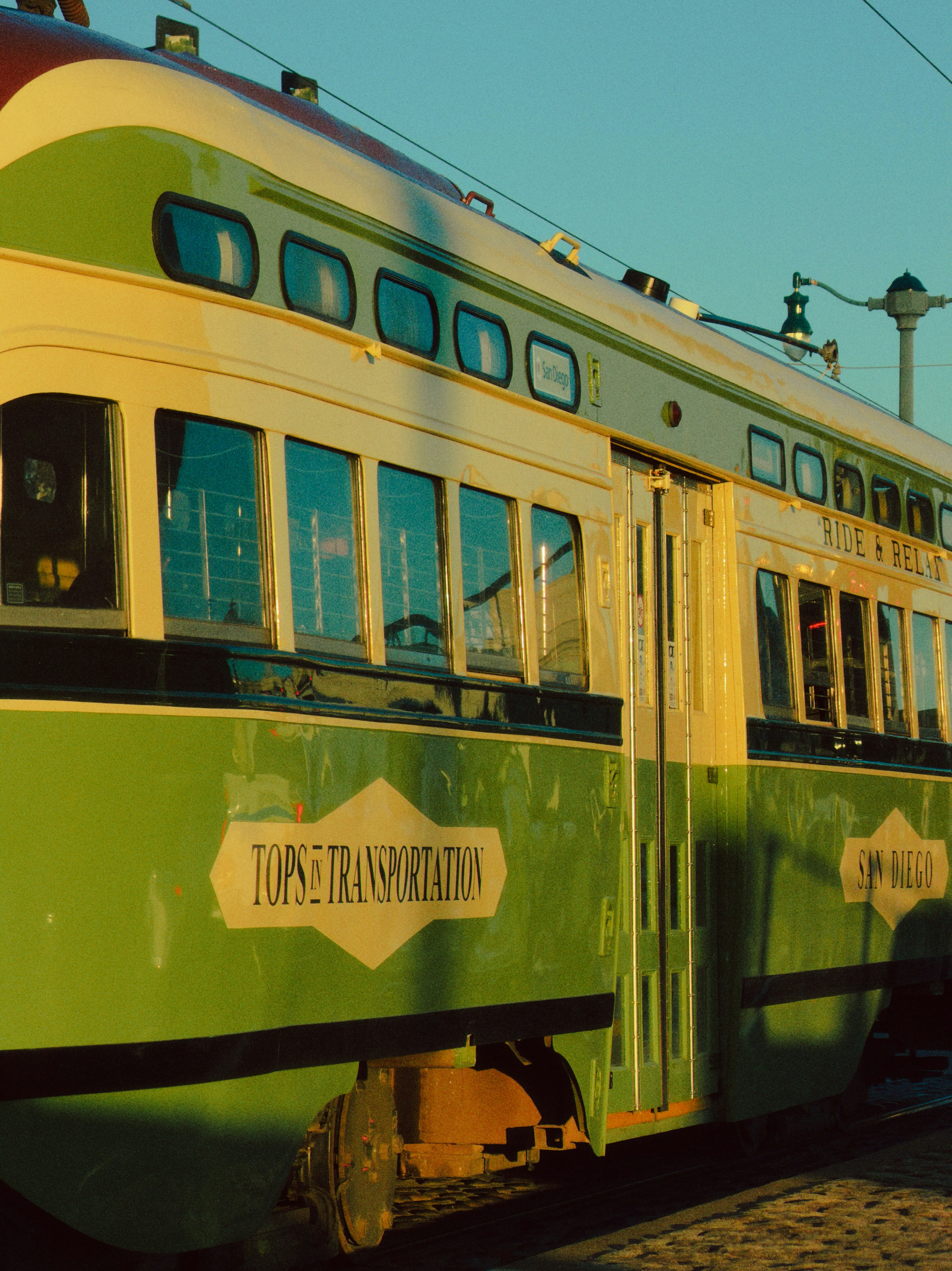 A green and yellow vintage trolley car