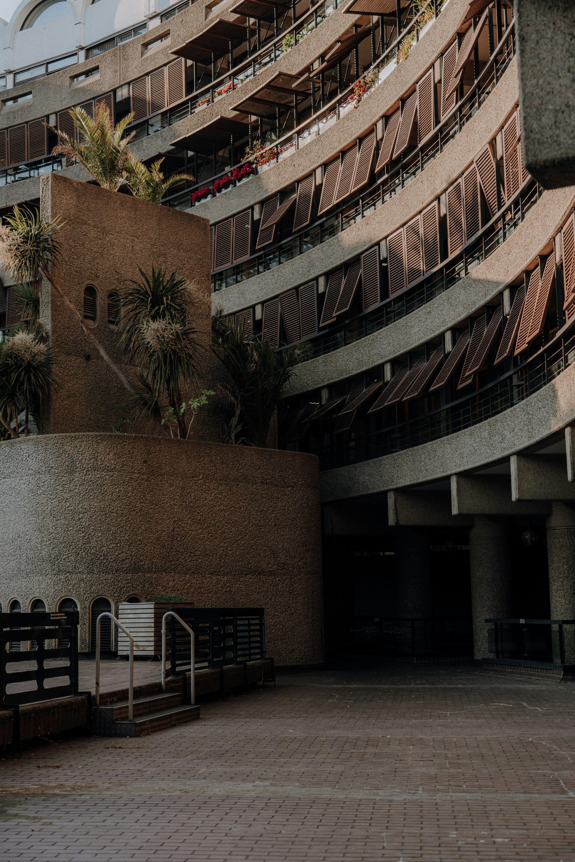Curving brutalist architecture with balconies and plants