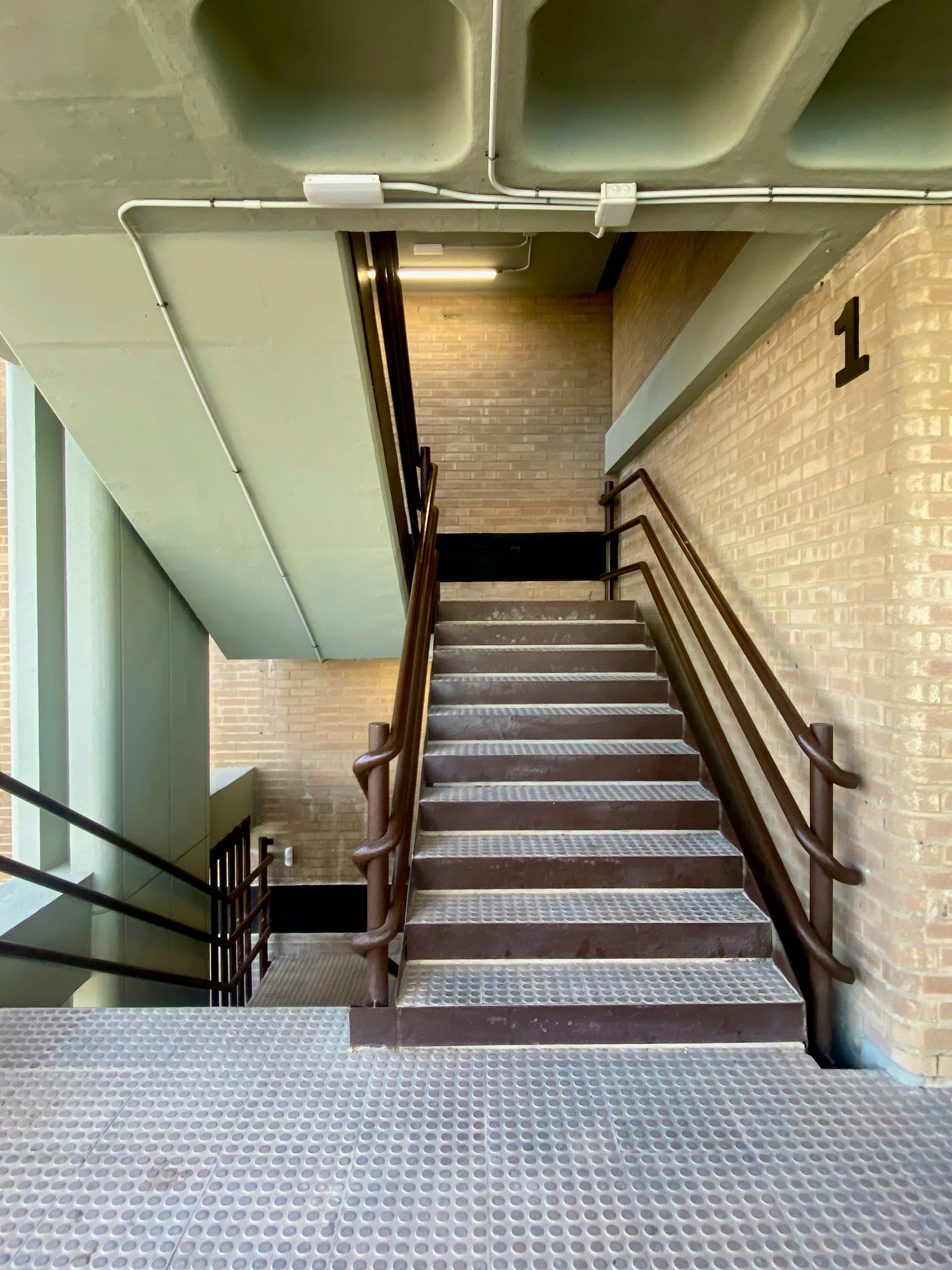 Staircase with metal railings and brick wall