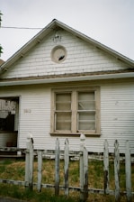 Old white house with weathered picket fence