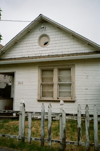 Old white house with weathered picket fence