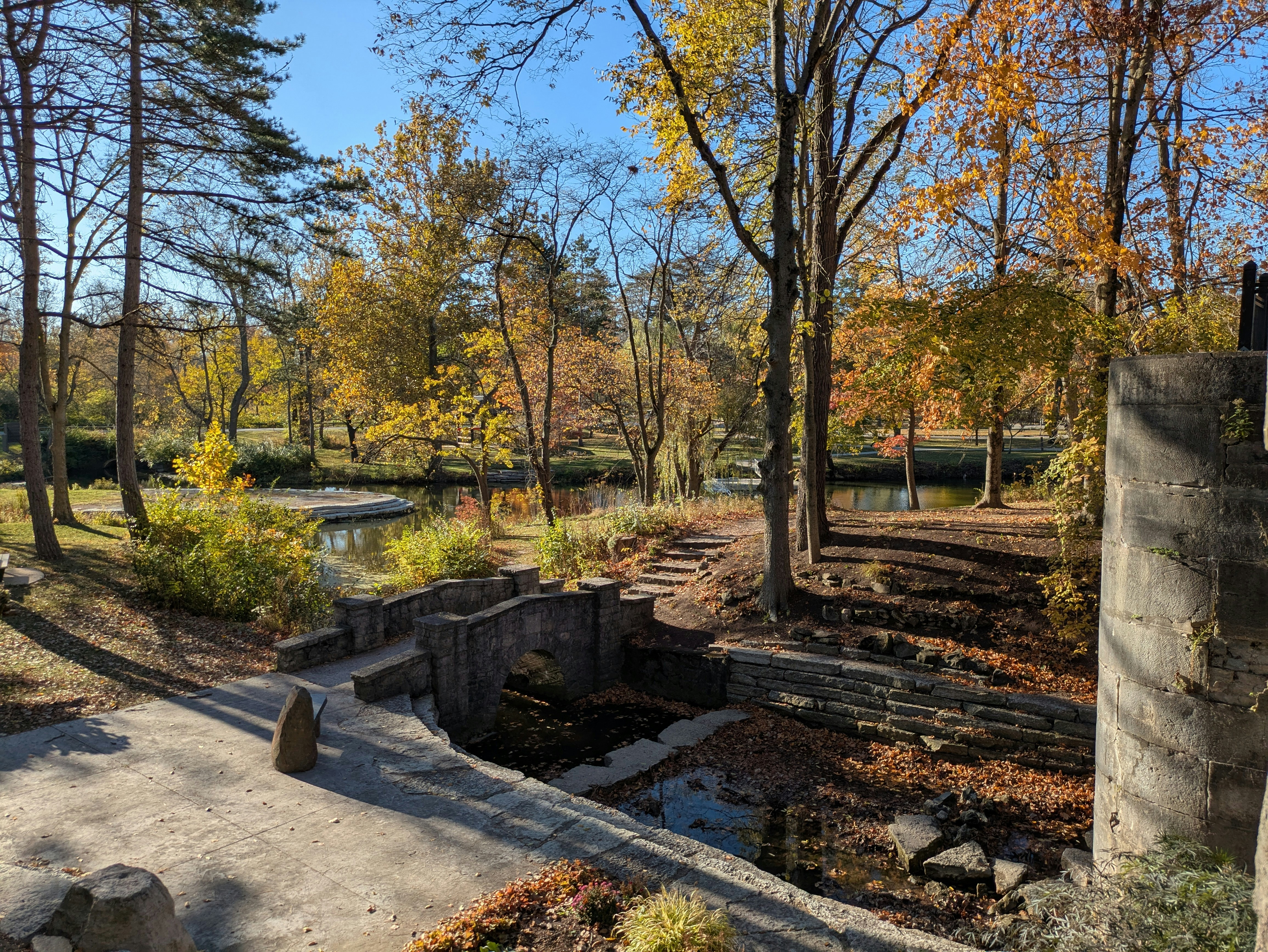 Autumn park with stone bridge and colorful trees