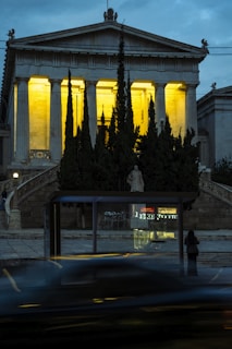 Neoclassical building with illuminated columns at dusk.