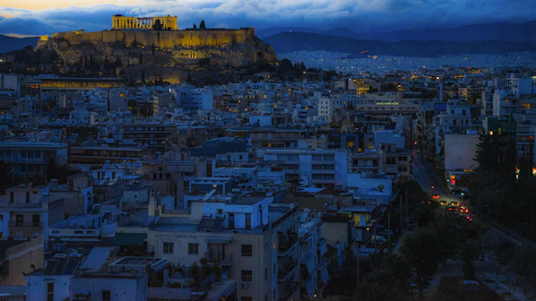Cityscape with ancient acropolis at dusk.