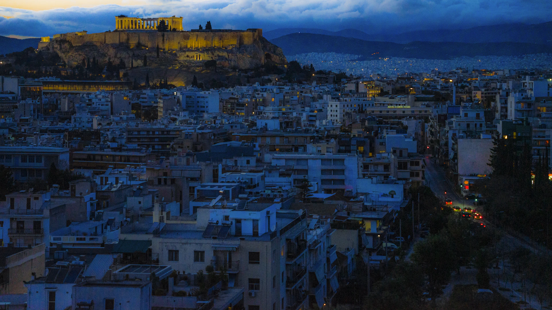 Cityscape with ancient acropolis at dusk.