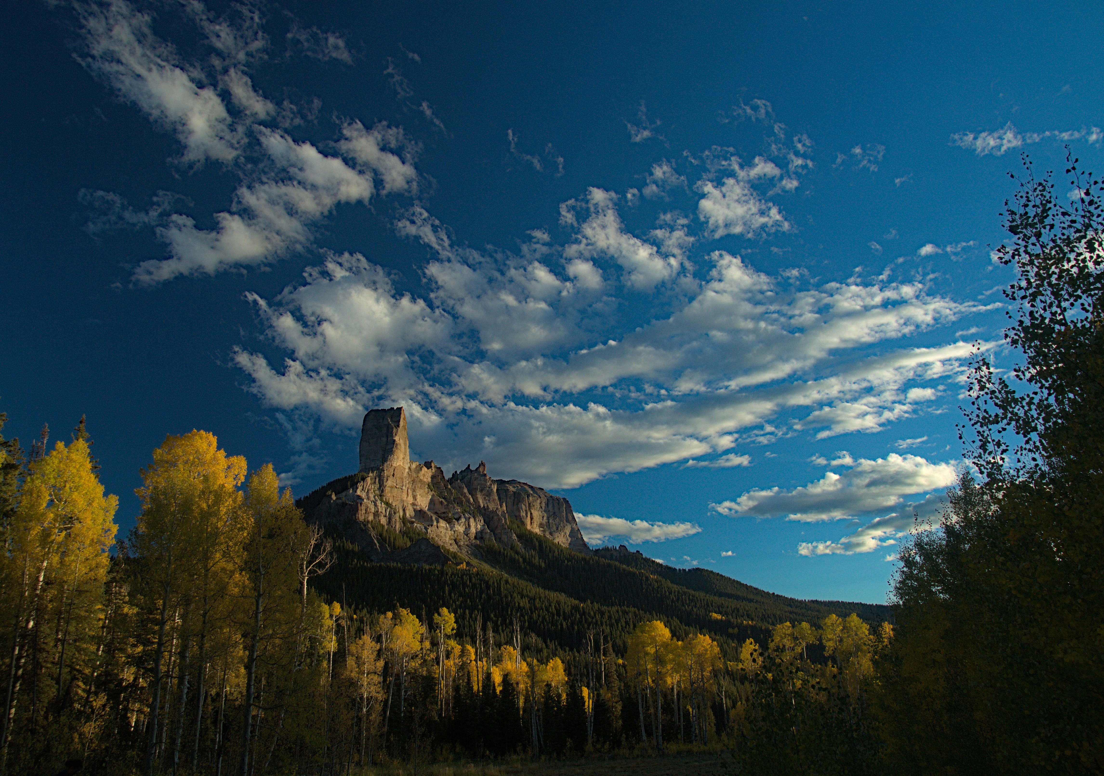 Dramatic rock formation under a cloudy blue sky