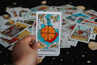 Hand holding a tarot card with wheel of fortune
