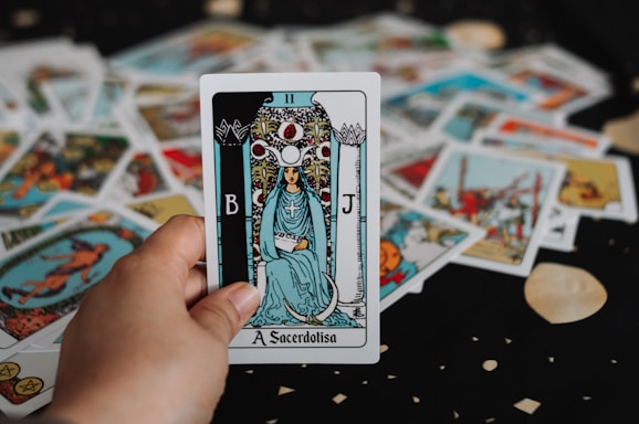Hand holding a tarot card over a spread in Queens New YorK City