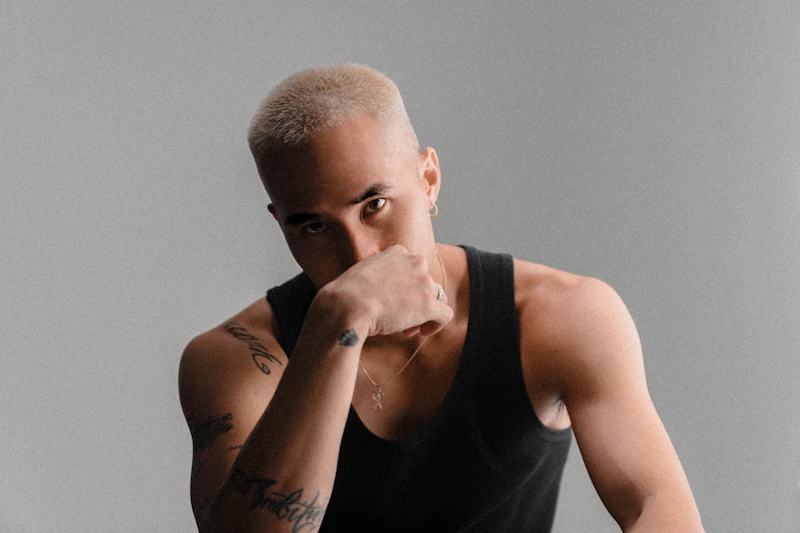 一位金发寸头、身穿黑色背心的男士，硬朗帅气