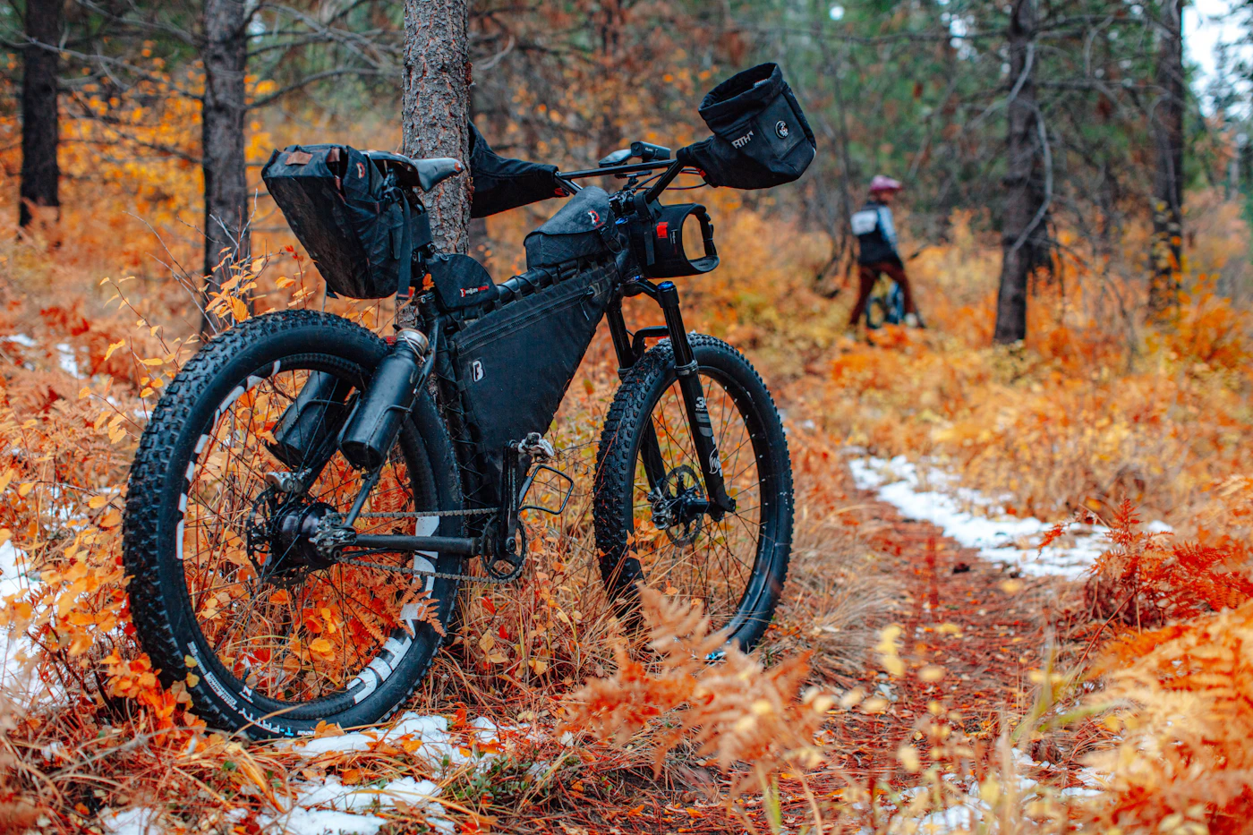 Black electric mountain bike parked on a forested gravel trail