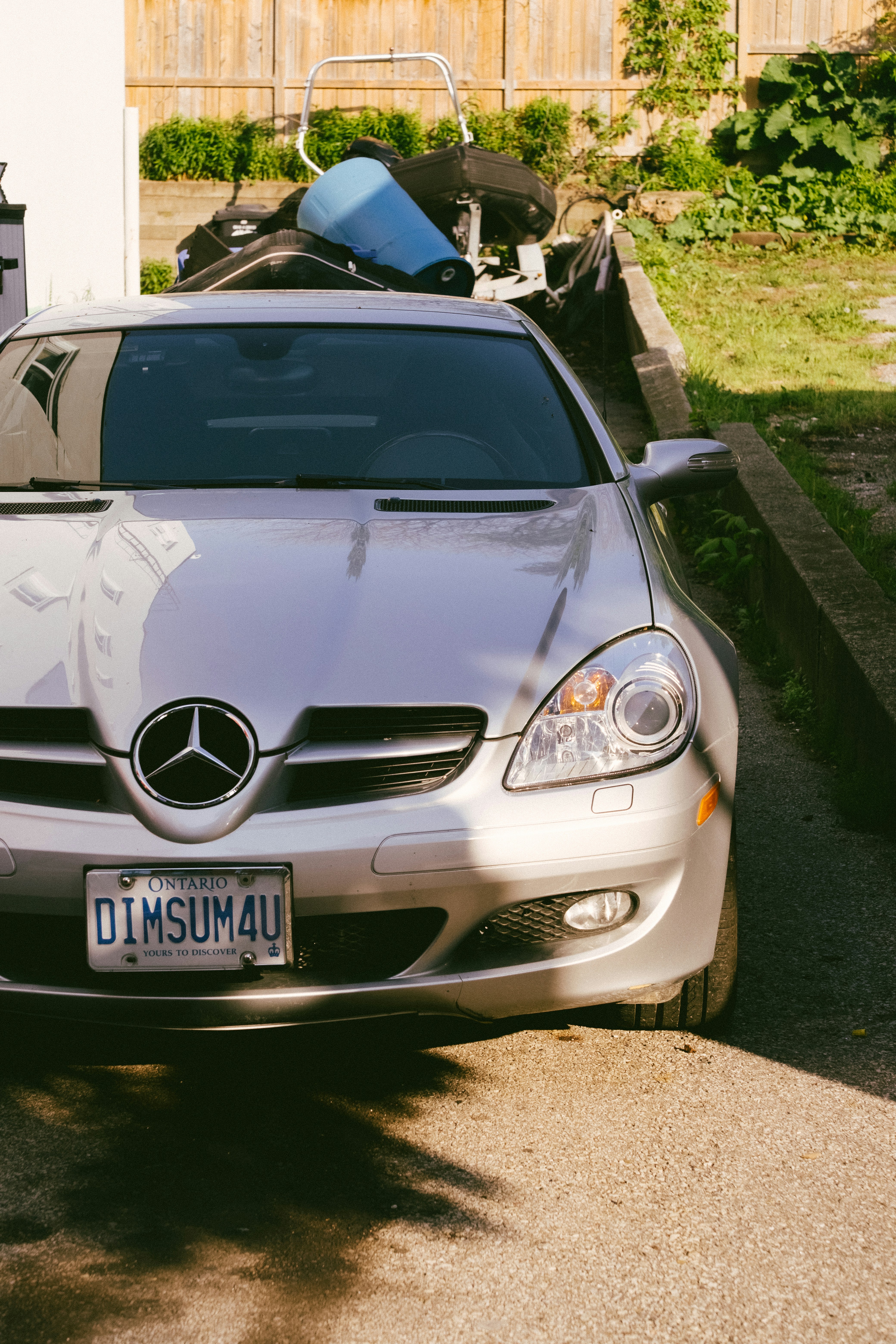 Silver mercedes-benz parked on a sunny driveway.