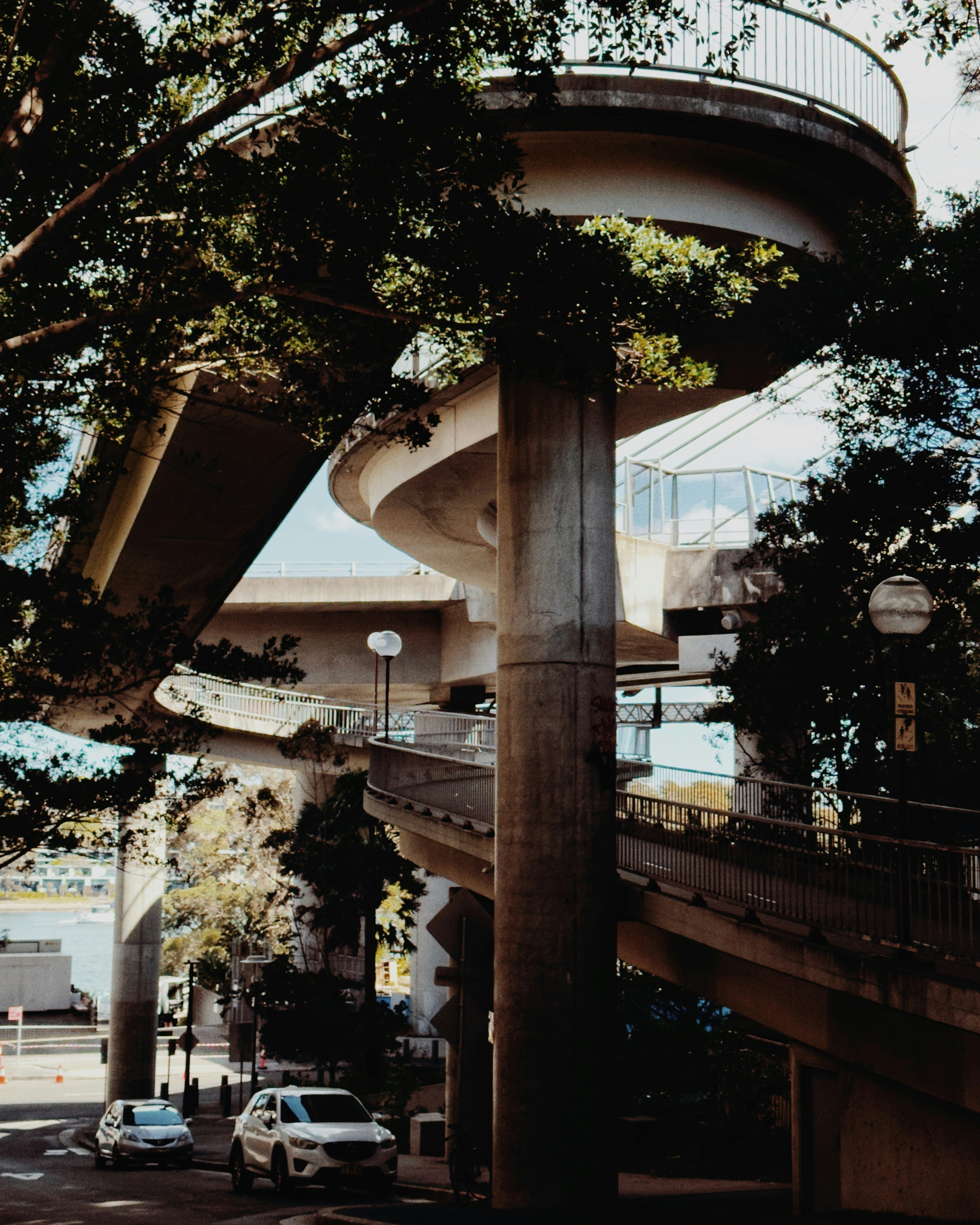 Passerelle en spirale moderne avec des arbres et des voitures en dessous