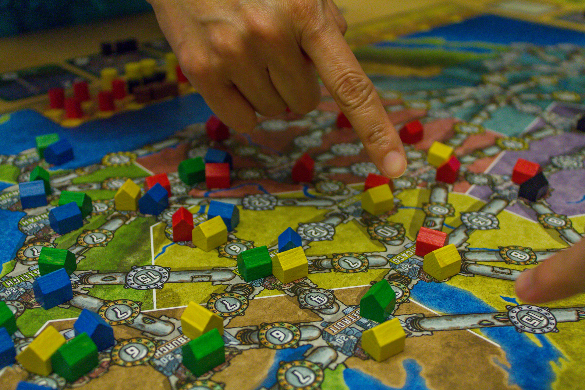 People playing a board game with colorful pieces.