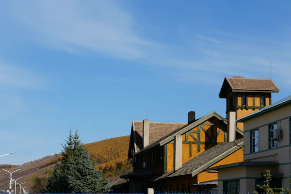 Remodeling Hillside Properties: Buildings with a clear blue sky and autumn trees.