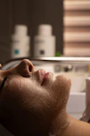 Woman's face with cleansing foam during facial treatment.