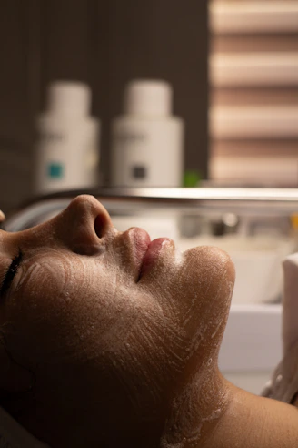 Woman's face with cleansing foam during facial treatment.