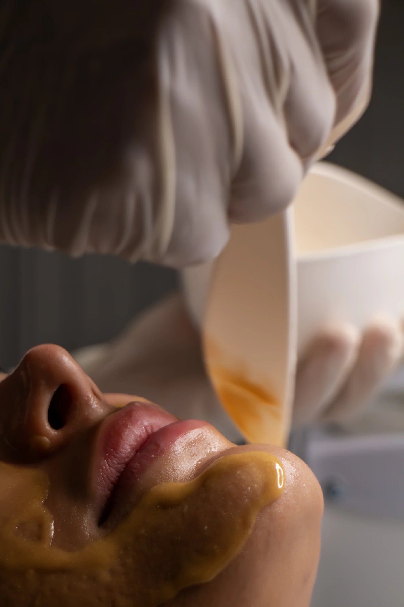 Beautician applying a calming facial treatment, representing the clinical care step of an LED Acne Therapy session
