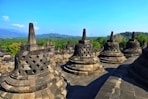 Ancient stupas at borobudur temple complex under blue sky