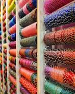 Colorful bangles displayed on shelves in a store.