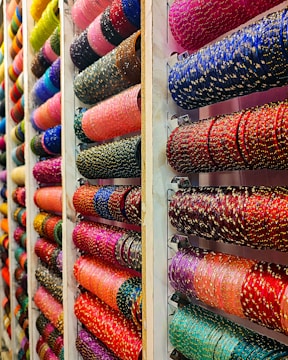 Colorful bangles displayed on shelves in a store.