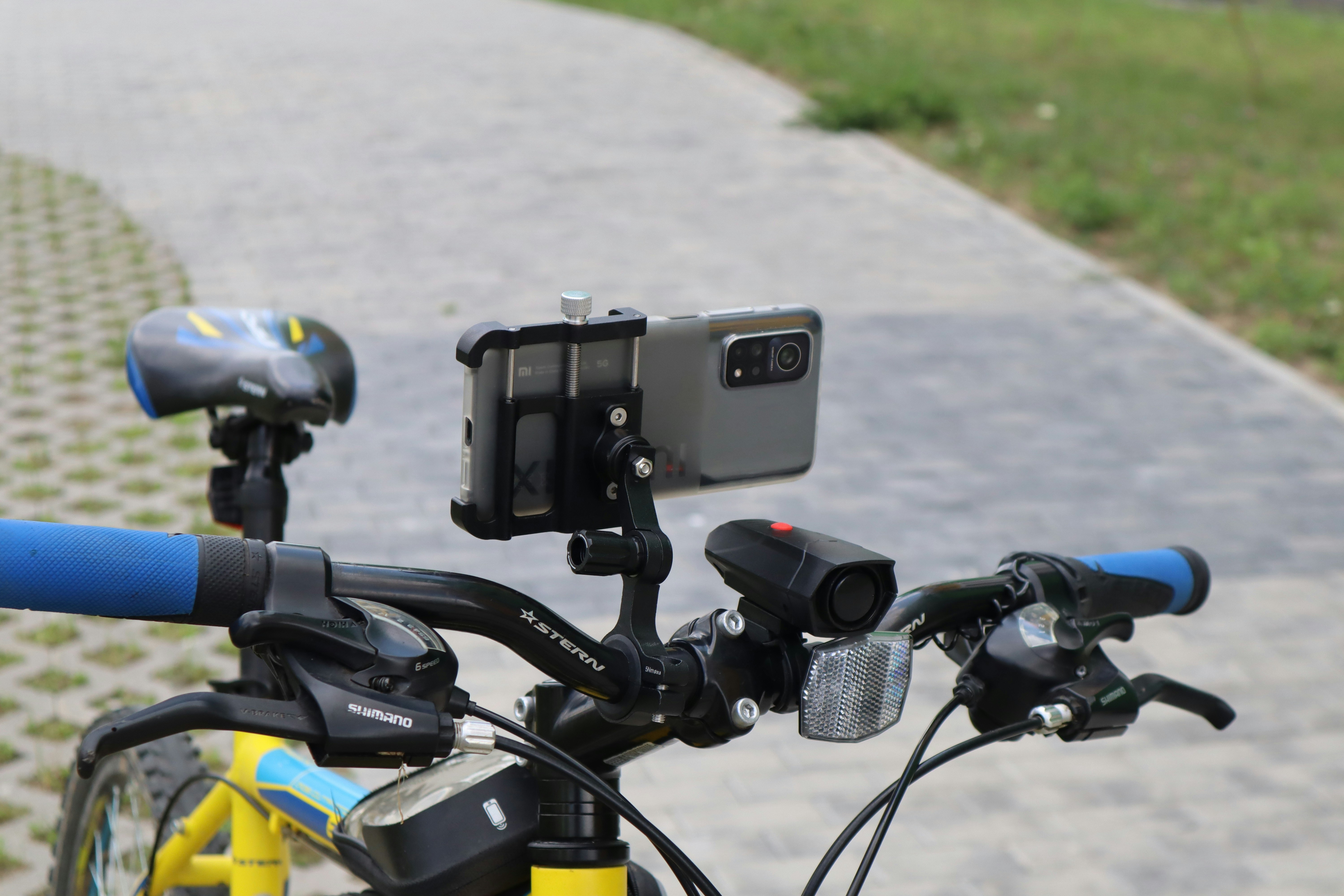 Bicycle handlebars with phone and lights attached.