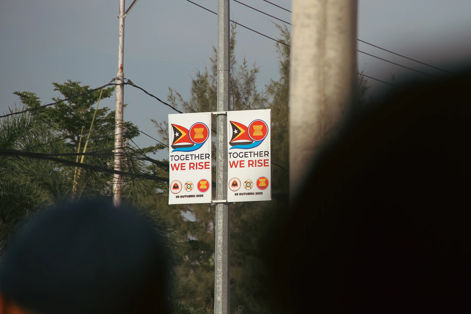 Two signs with "together we rise" text and logos.