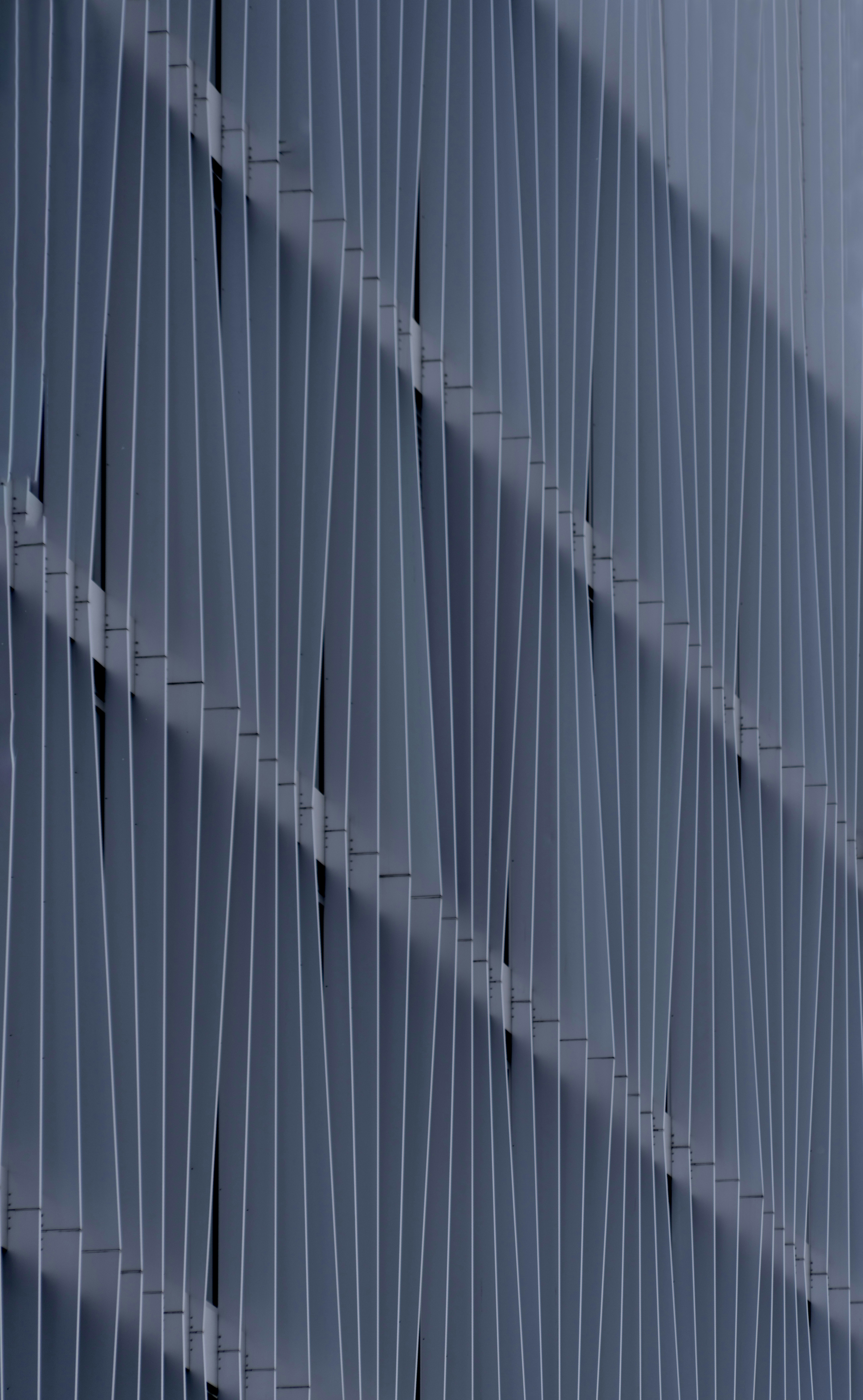Modello astratto di lamelle grigie verticali con ombre.