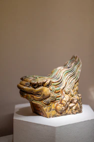 Ancient ceramic dragon head sculpture with green and yellow glaze