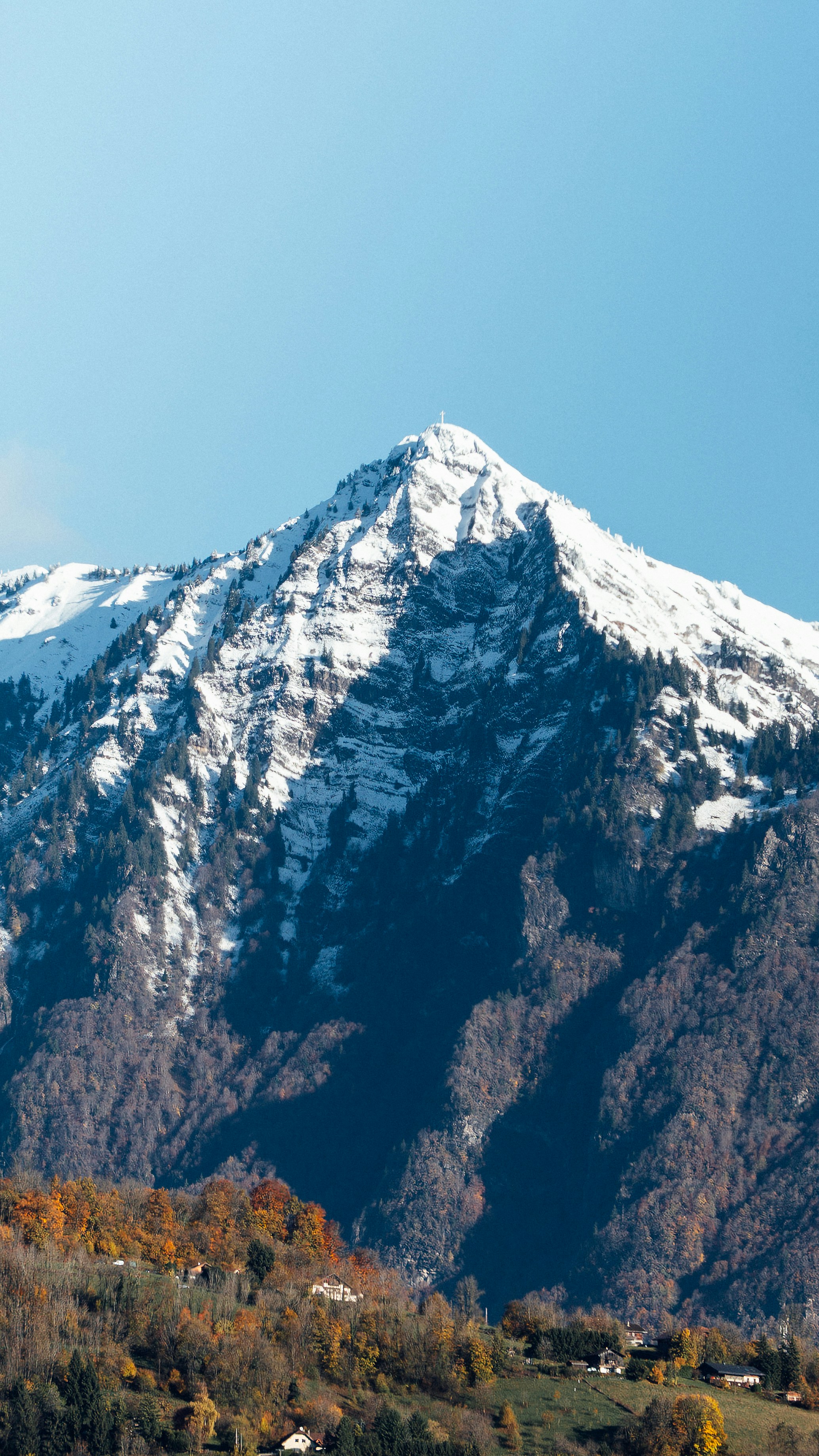 Snow-capped mountain peak against a clear blue sky.