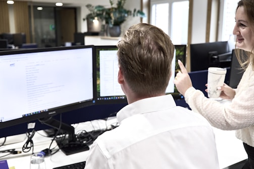 Two colleagues collaborating at office computers