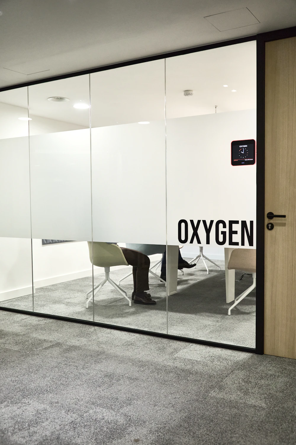 A modern conference room with frosted glass walls used for client and portfolio review meetings