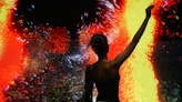 Woman silhouetted against vibrant, abstract art display