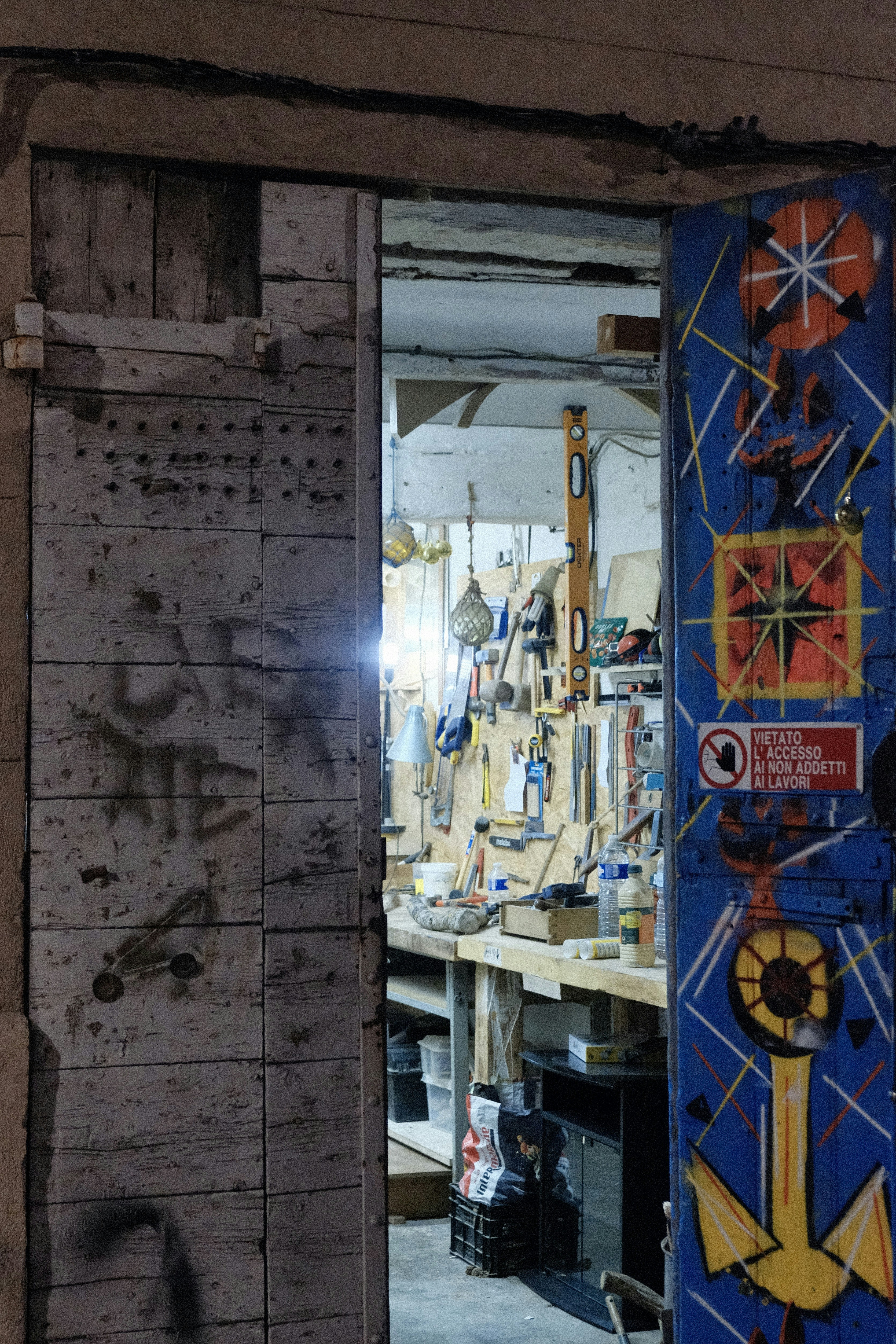 Interior da oficina com ferramentas na parede e porta decorada