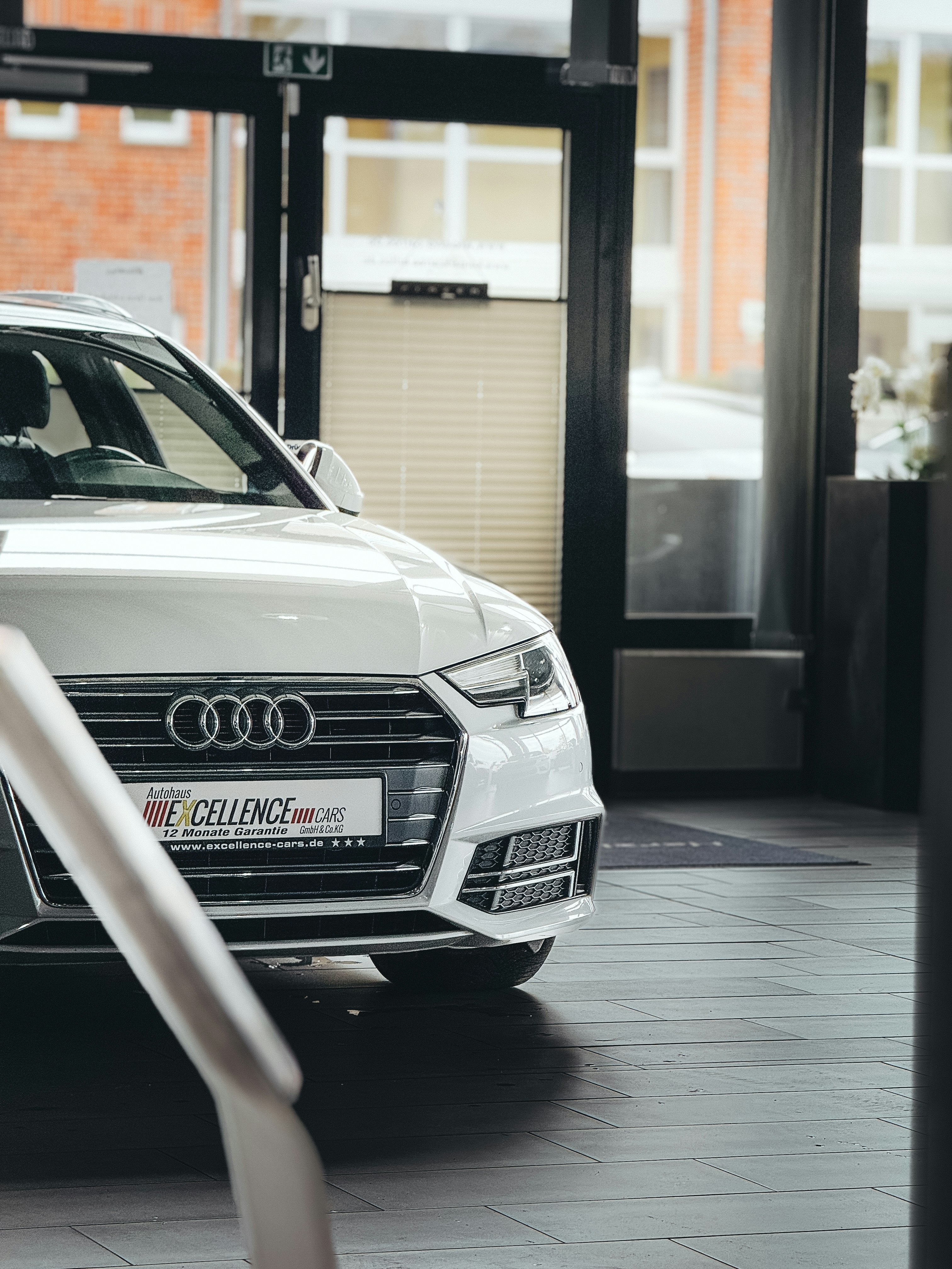 White audi car parked inside a showroom.