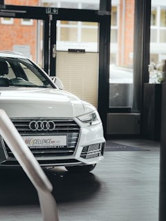 White audi car parked inside a showroom.