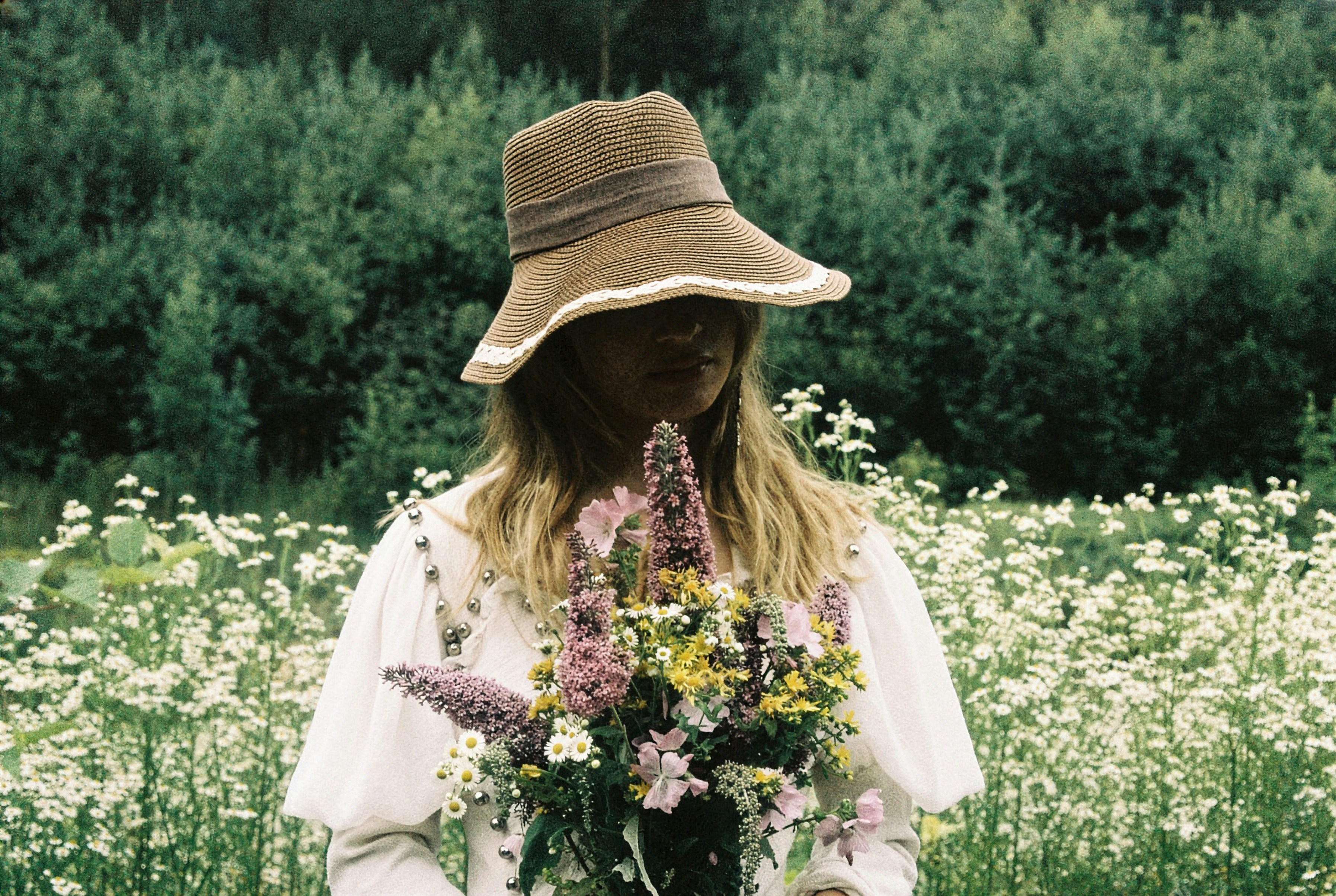 Woman in hat holding wildflowers in a field photo – Free Spring Image ...
