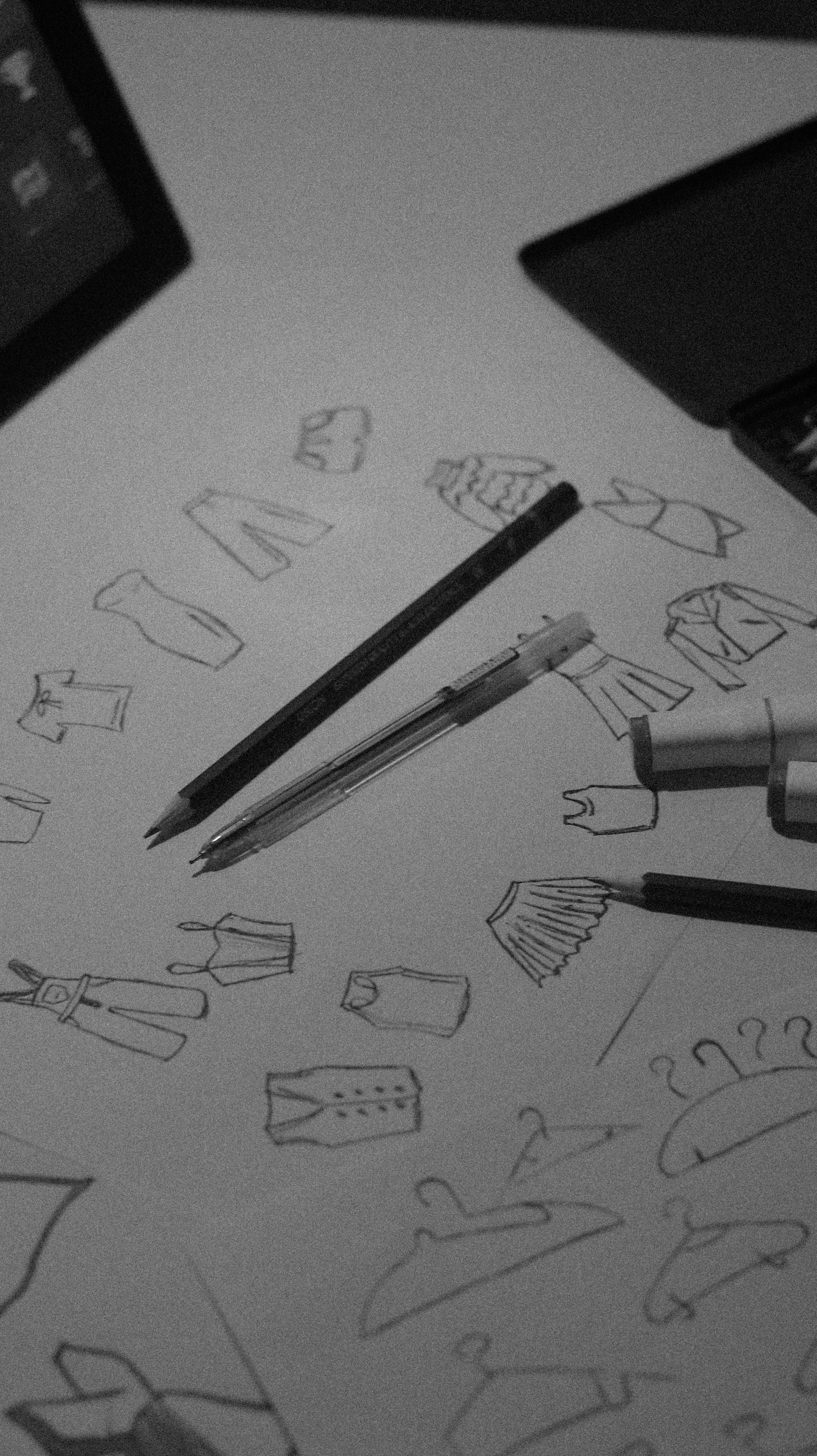 Sketches of clothing and hangers with pens.