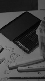 Pencils and fashion sketches on a table